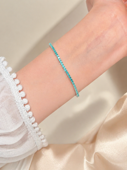 Turquoise bracelet on a wrist with a white lace garment