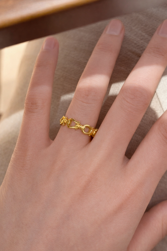 Gold ring on a person's finger with a neutral background