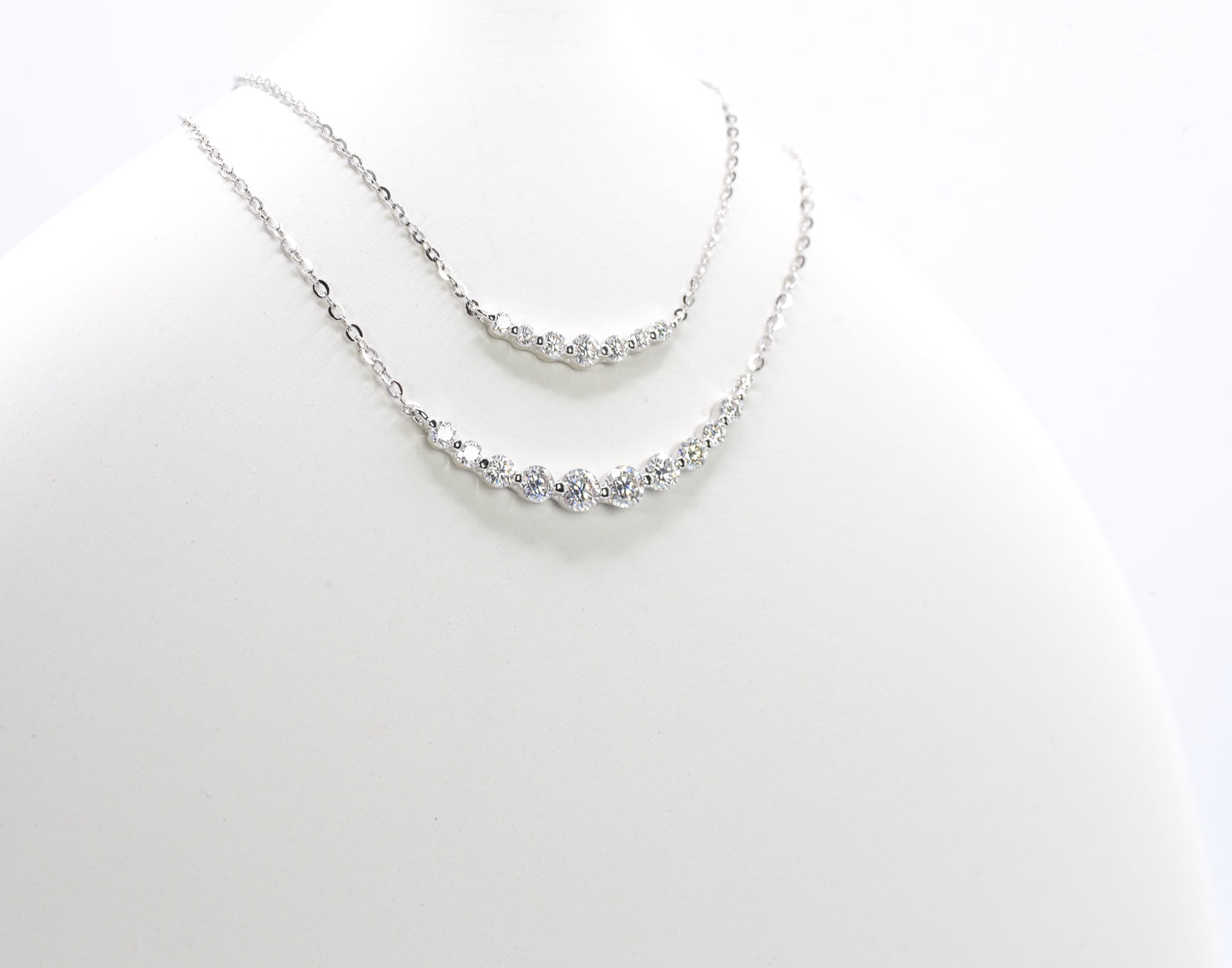 Silver necklaces with small Moissanite Stones on a white background