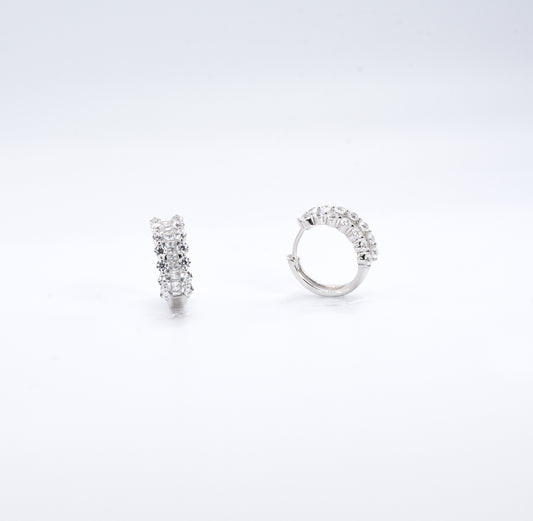 Pair of silver hoop earrings with clear gemstones on a white background