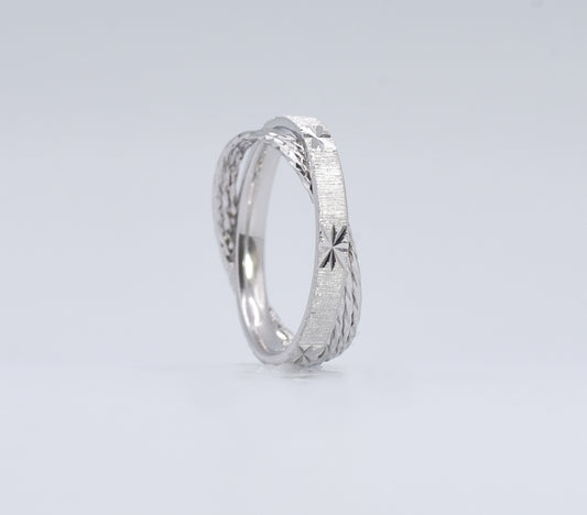 Silver ring with textured design on a light gray background
