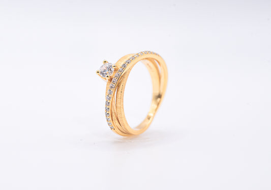 gold color ring with diamond accents on a light gray background