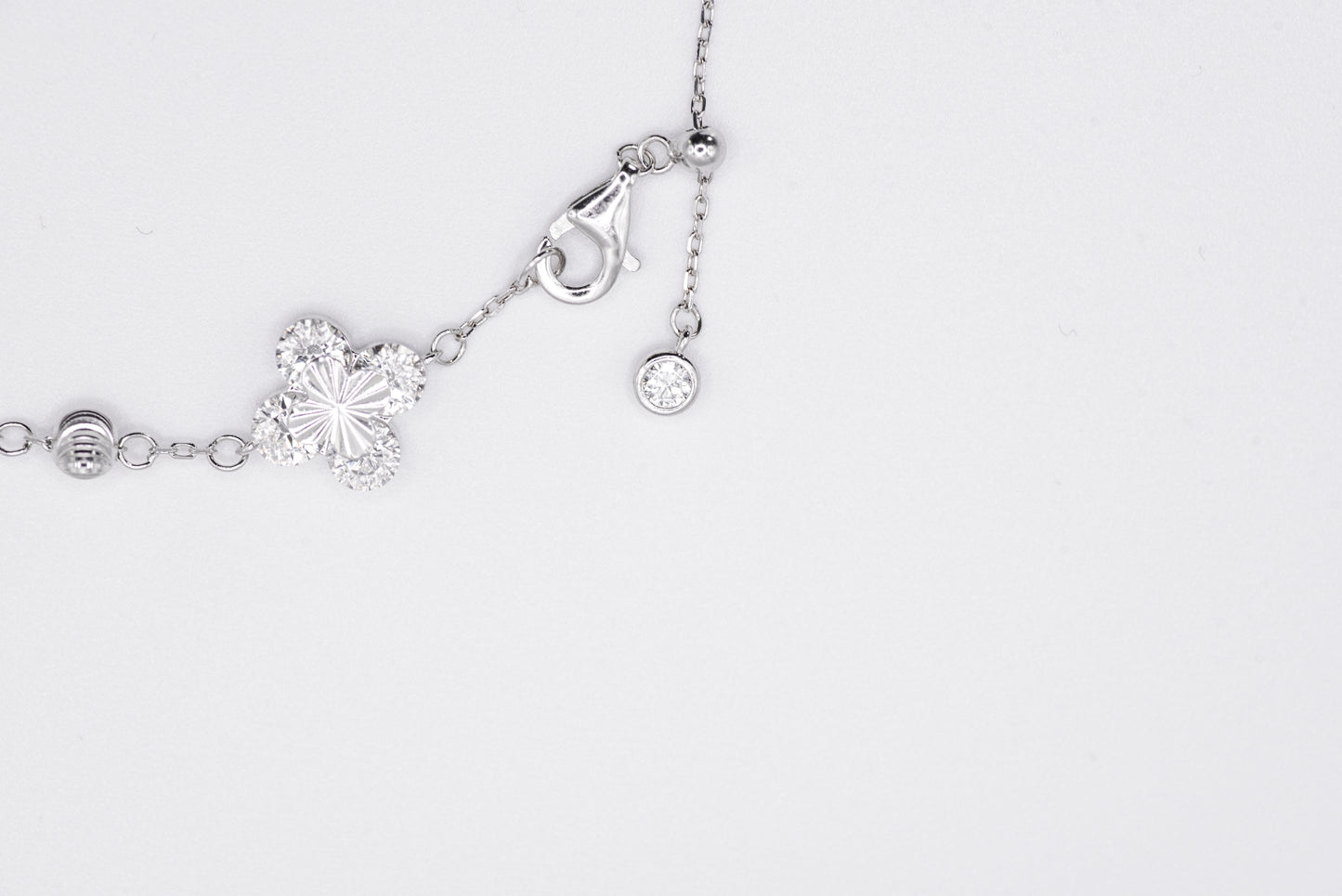 Silver bracelet with floral designs on a white background