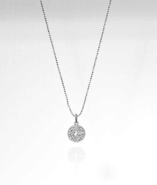Silver necklace with a round pendant on a light gray background