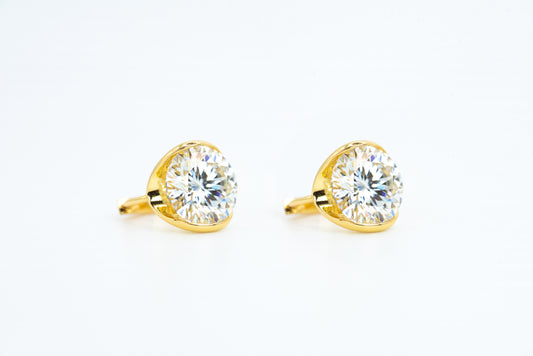 Gold earrings with clear gemstones on a white background