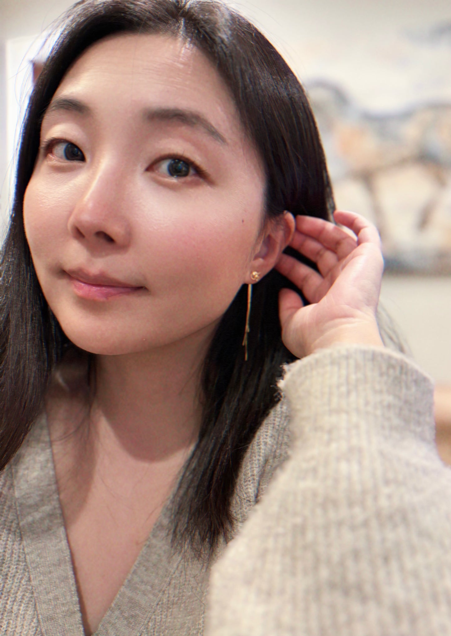 Woman adjusting an earring in a store setting