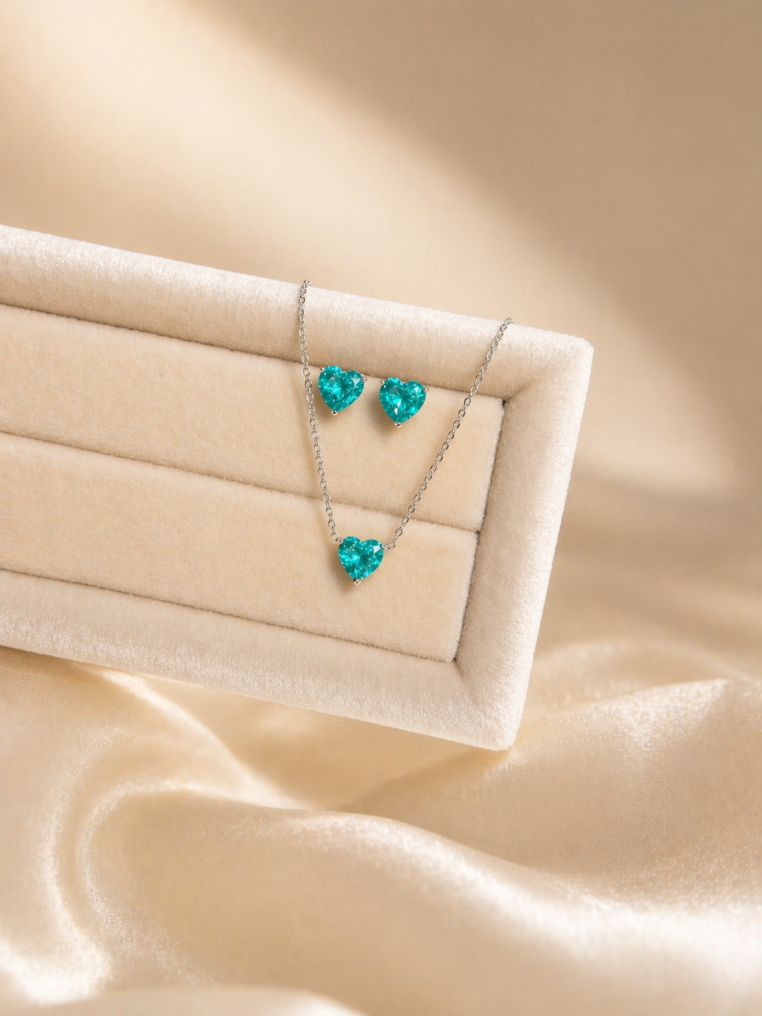 Turquoise heart-shaped jewelry set on a beige fabric background