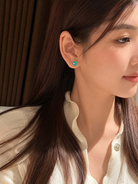 Lab-grown Paraiba cushion-cut stud earrings by Lunelle Atelier, featuring vibrant blue-green gemstones on a sleek silver setting.