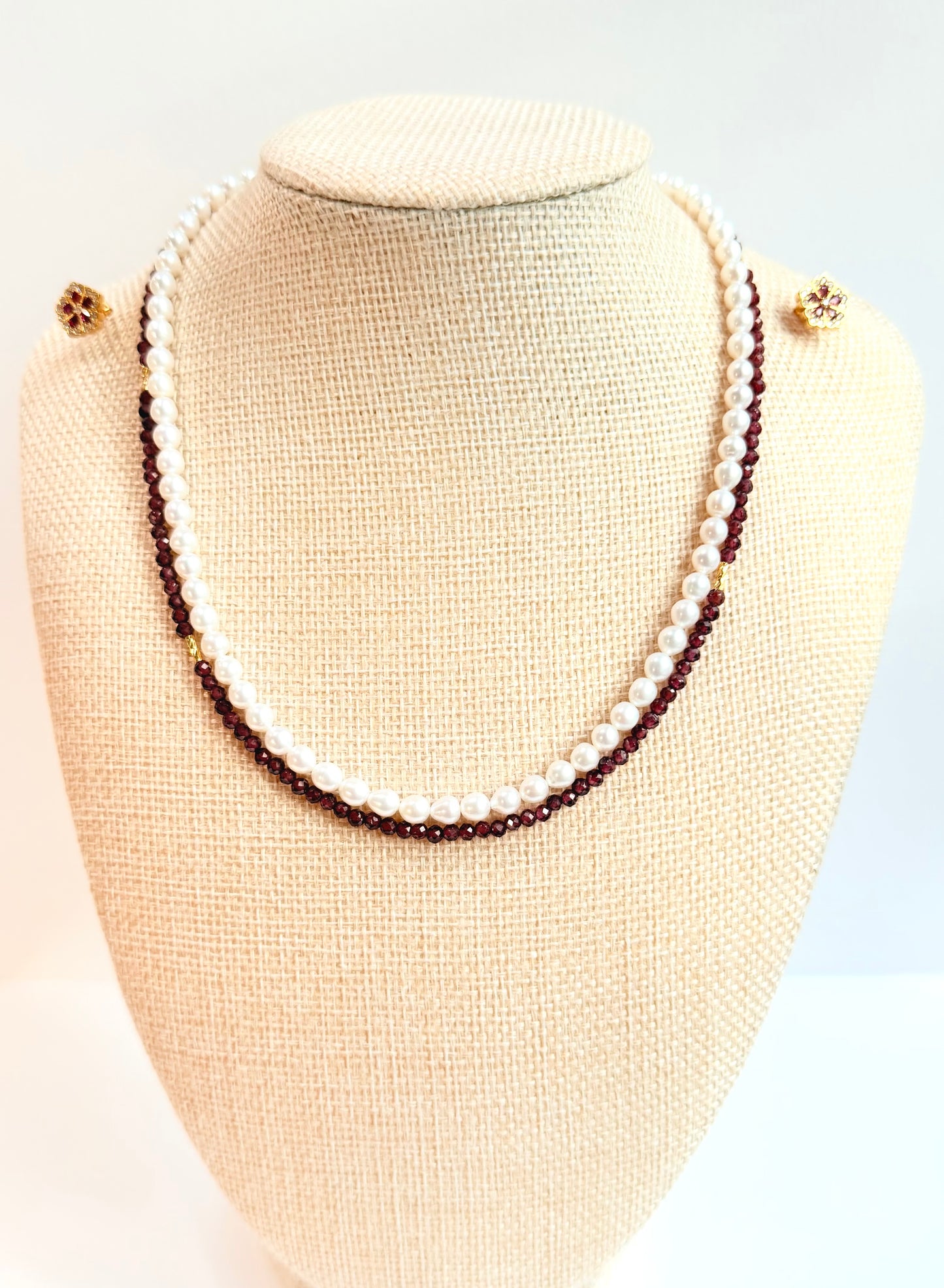 Two-layered pearl necklace on a mannequin bust against a white background