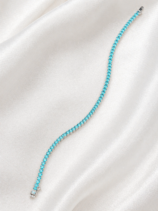 Turquoise beaded bracelet on a white satin surface