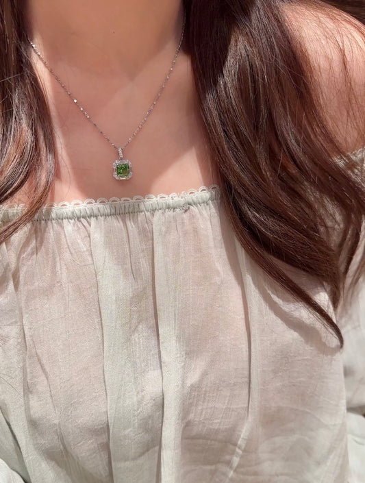 Lunelle Atelier green cushion halo pendant necklace with a central green gemstone and elegant silver setting.