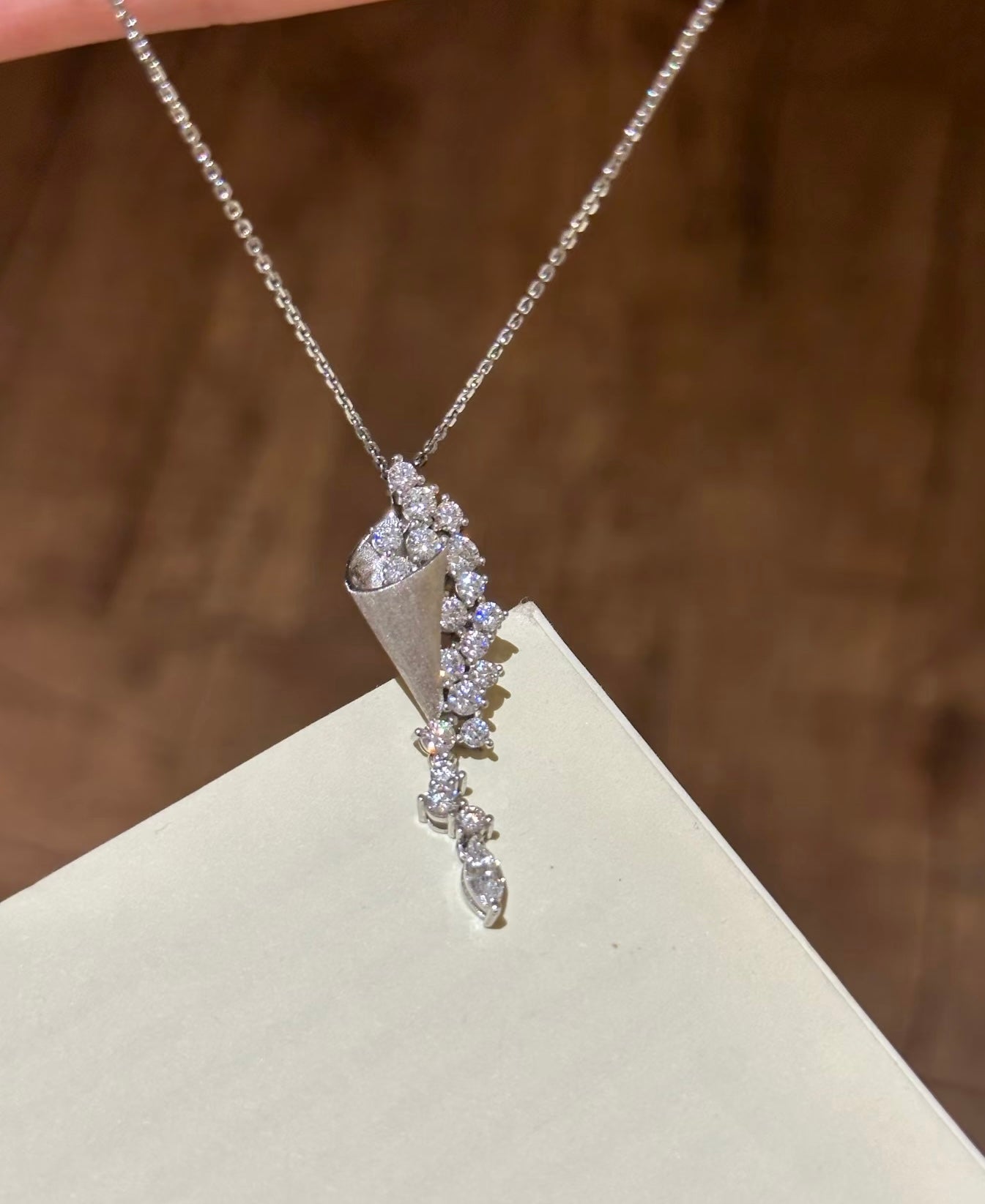 Silver necklace with a decorative pendant on a beige surface