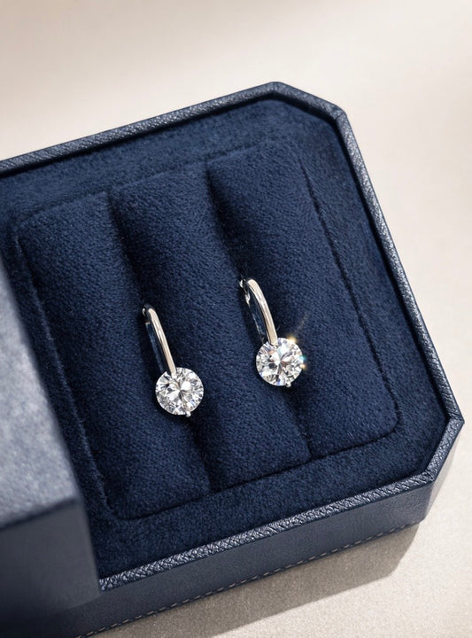 Diamond earrings in a navy blue jewelry box