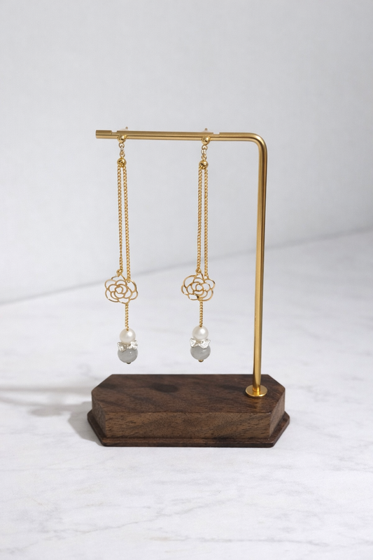Gold earring stand with earrings on a white background