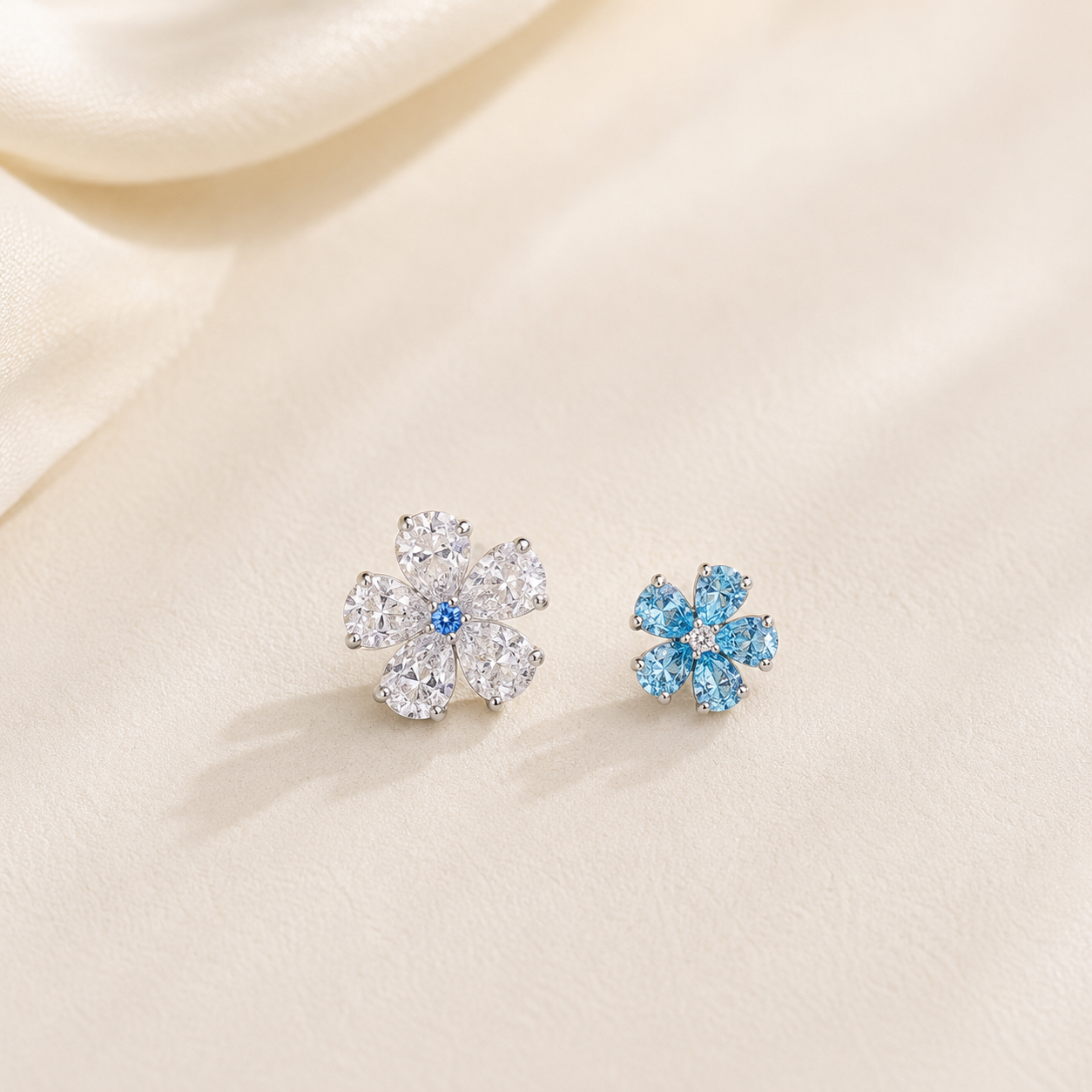 Lunelle Atelier twin bloom blue and white mismatched flower stud earrings on ears, showcasing floral jewelry design.