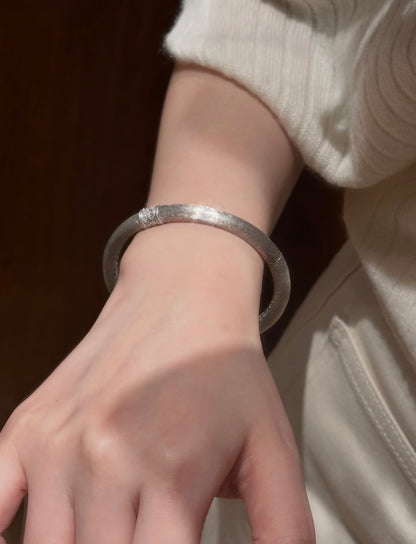 Hand-brushed rotating accent bangle bracelet by Lunelle Atelier featuring a sleek, modern design and rotating centerpiece.