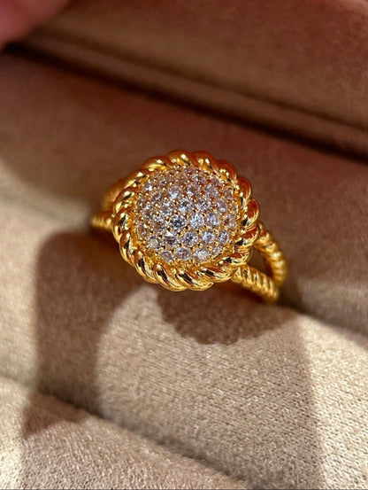 Gold ring with diamond accents on a beige fabric background