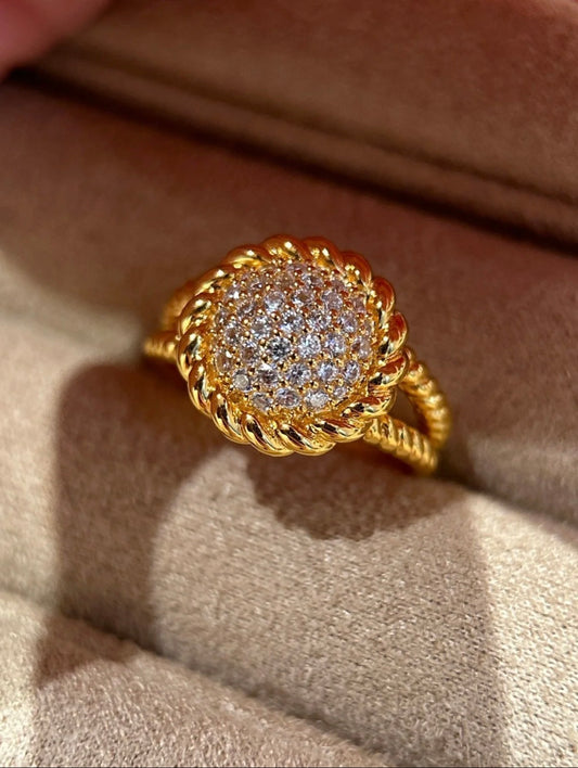 Gold ring with diamond accents on a beige fabric background