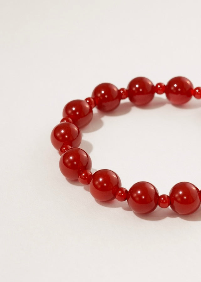 Red beaded bracelet on a white background