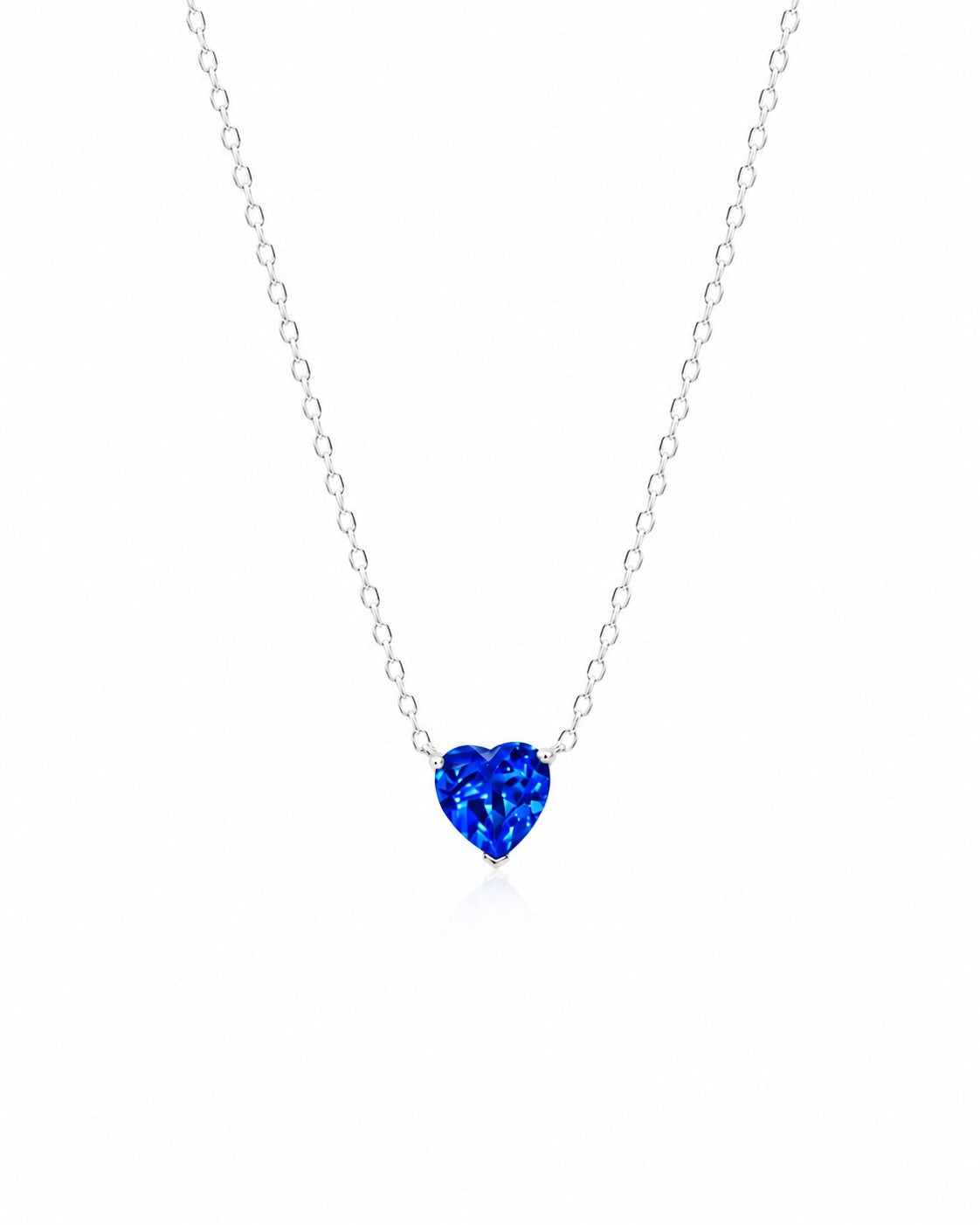 Heart-shaped blue gemstone necklace on a white chain against a white background