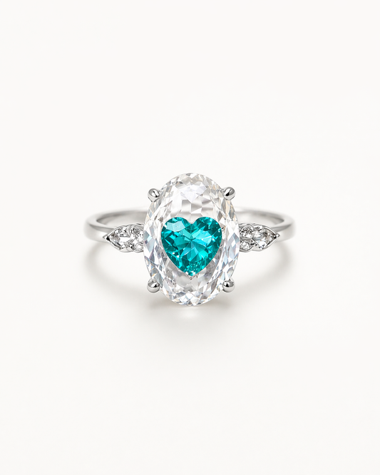 Ring with a heart-shaped green gemstone on a white background