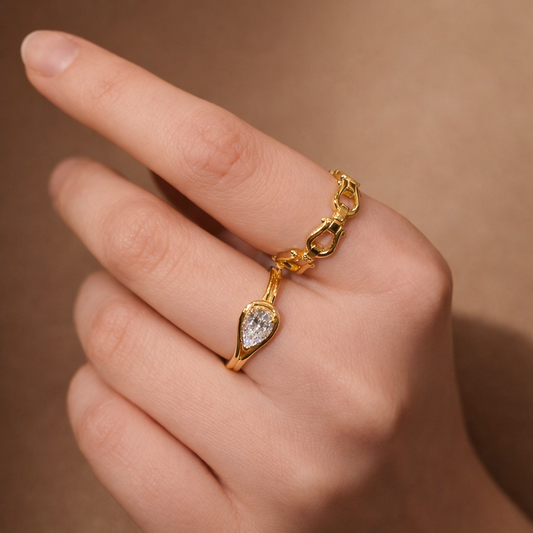 Gold bracelet with a diamond charm on a hand against a brown background