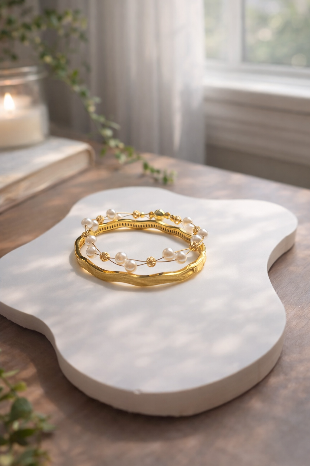 Gold bracelet on a white marble surface with a soft, natural light background