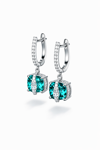 Pair of silver earrings with green gemstones on a white background