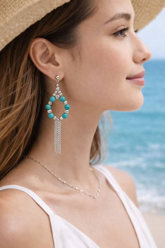 Woman wearing turquoise beaded earrings with a beach background