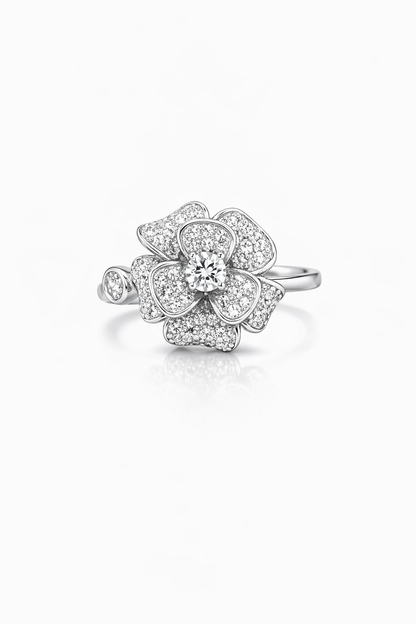 Silver flower-shaped ring with clear gemstones on a white background