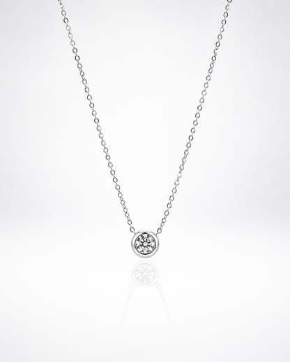 Silver necklace with a small round pendant on a white background
