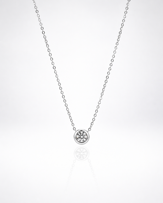 Silver necklace with a small round pendant on a white background