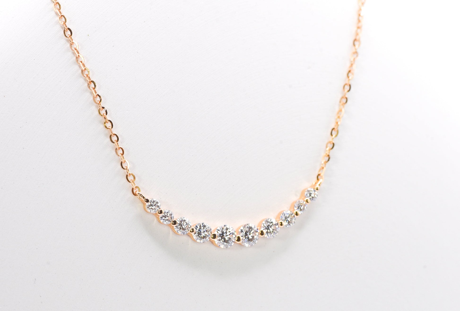 gold color necklace with small gemstones on a light gray background