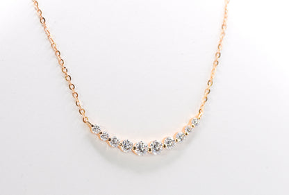 gold color necklace with small gemstones on a light gray background
