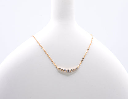 old color necklace with small gemstones on a light gray background