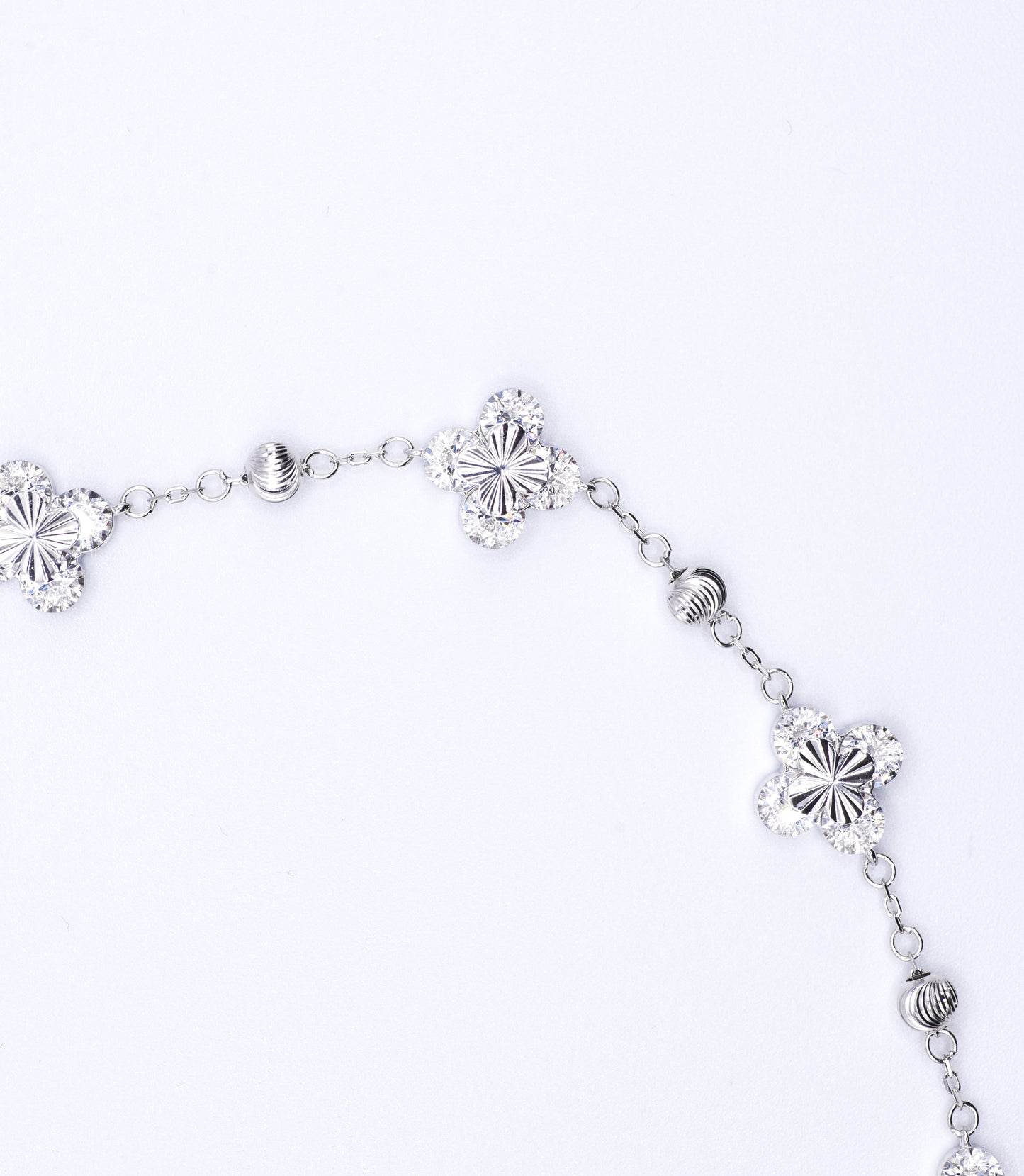 Silver bracelet with floral designs on a white background
