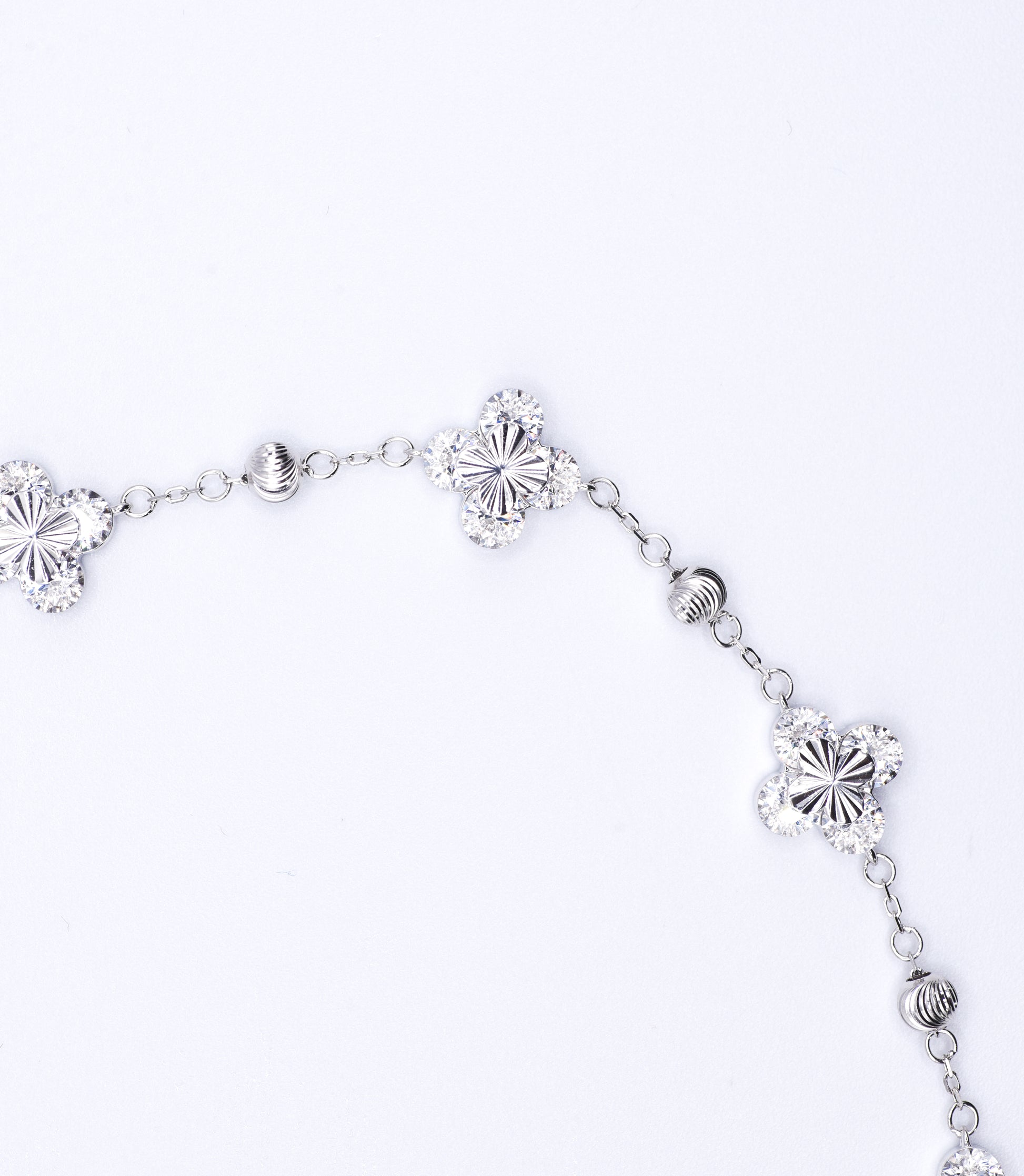 Silver bracelet with floral designs on a white background