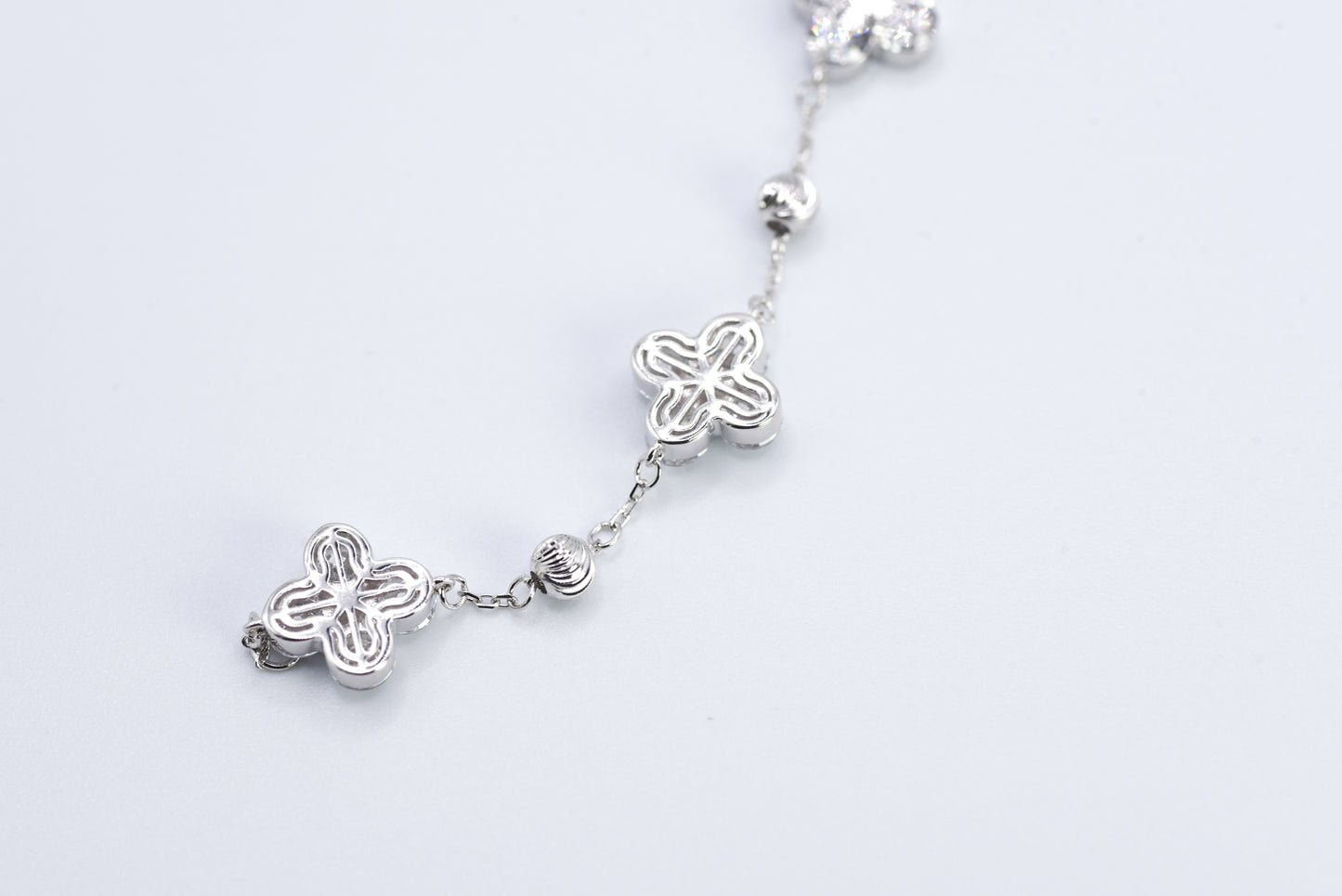 Silver bracelet with floral designs on a white background