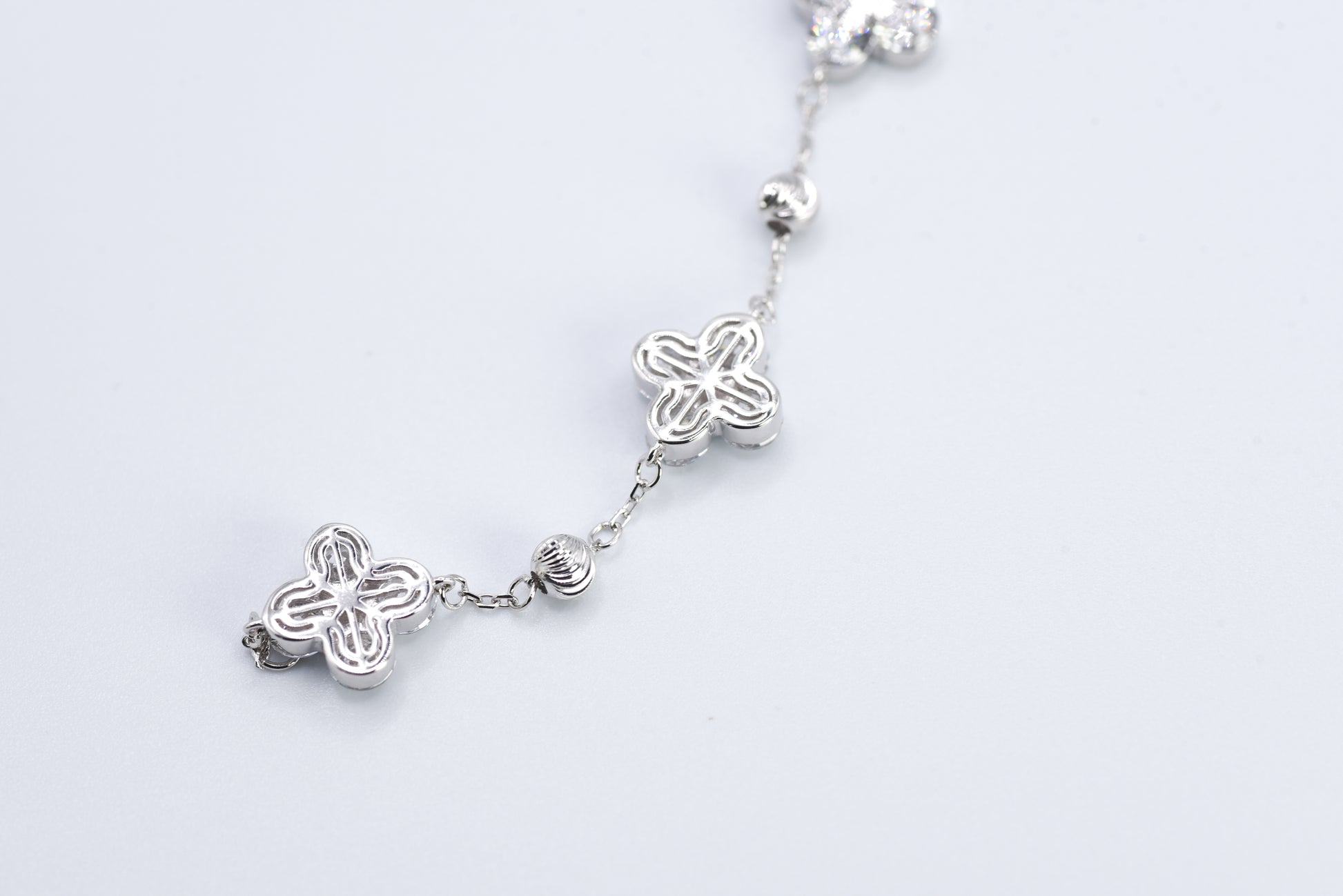 Silver bracelet with floral designs on a white background