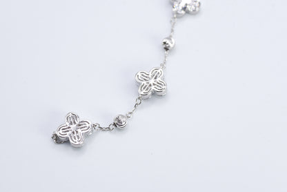 Silver bracelet with floral designs on a white background