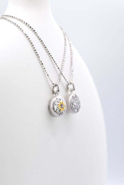 Two silver necklaces with pendants  against a white background