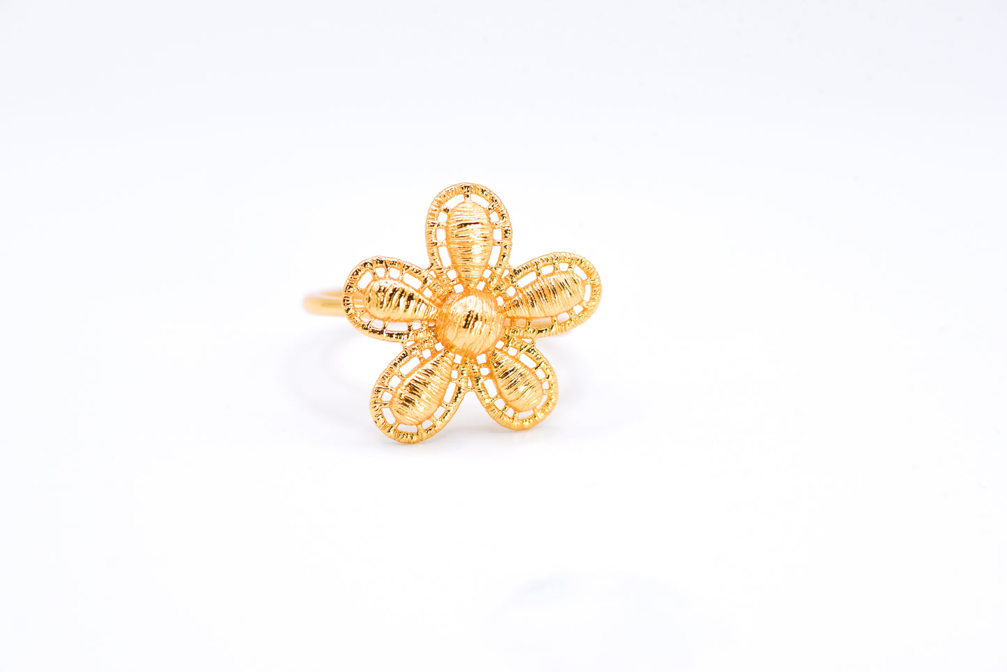 Gold flower-shaped ring on a white background