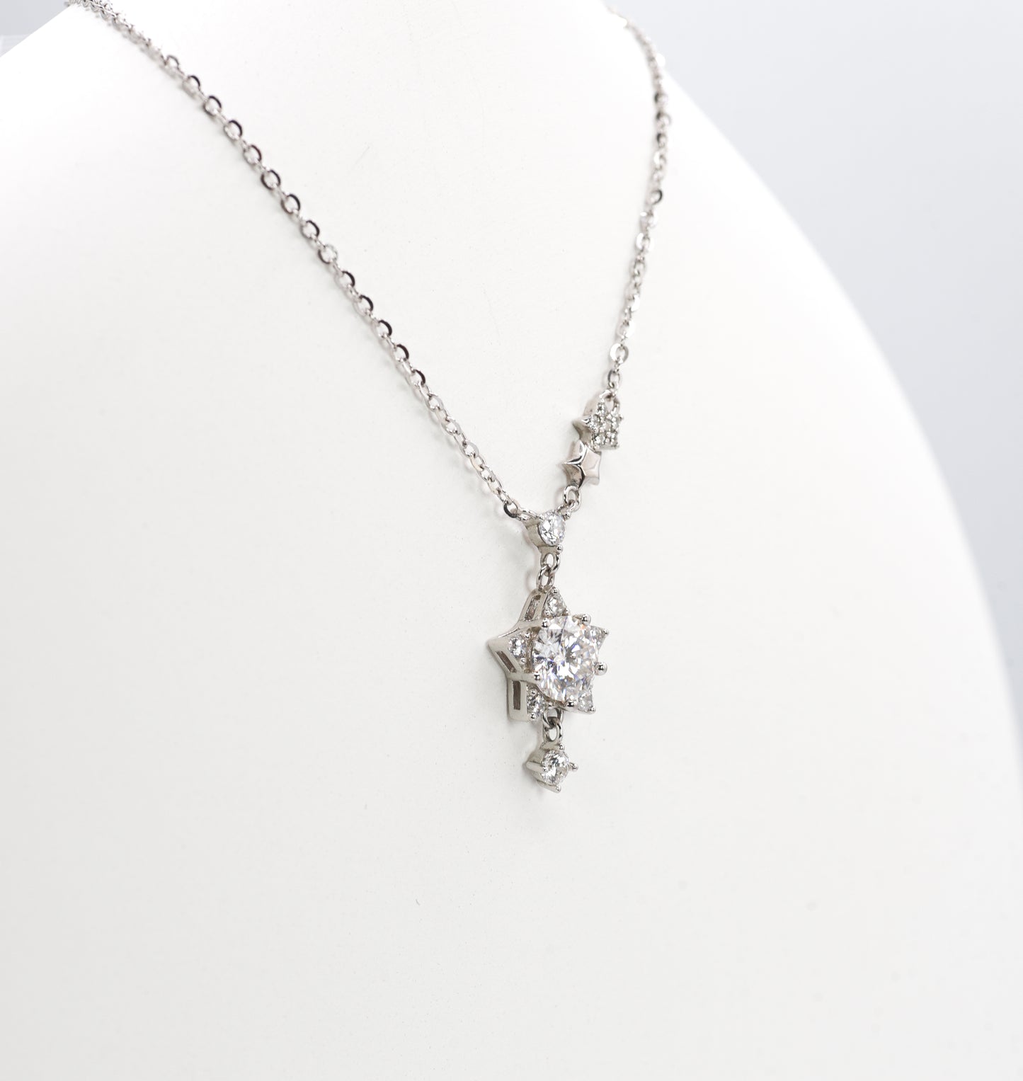 Silver necklace with a star-shaped pendant on a white background