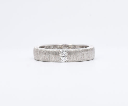 Silver ring with a textured band on a white background