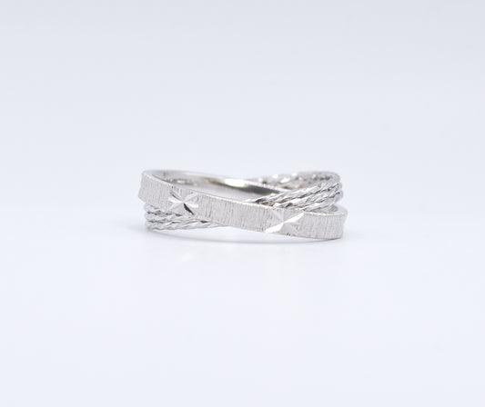 Silver ring with a textured design on a white background