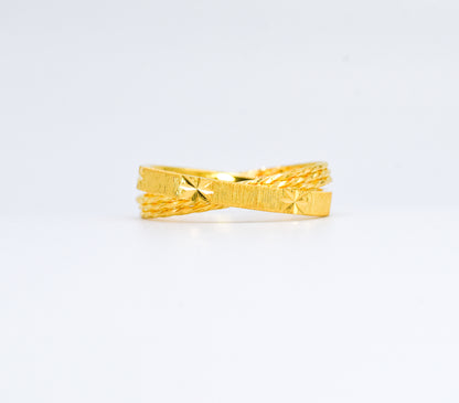 Gold ring with textured design on a white background