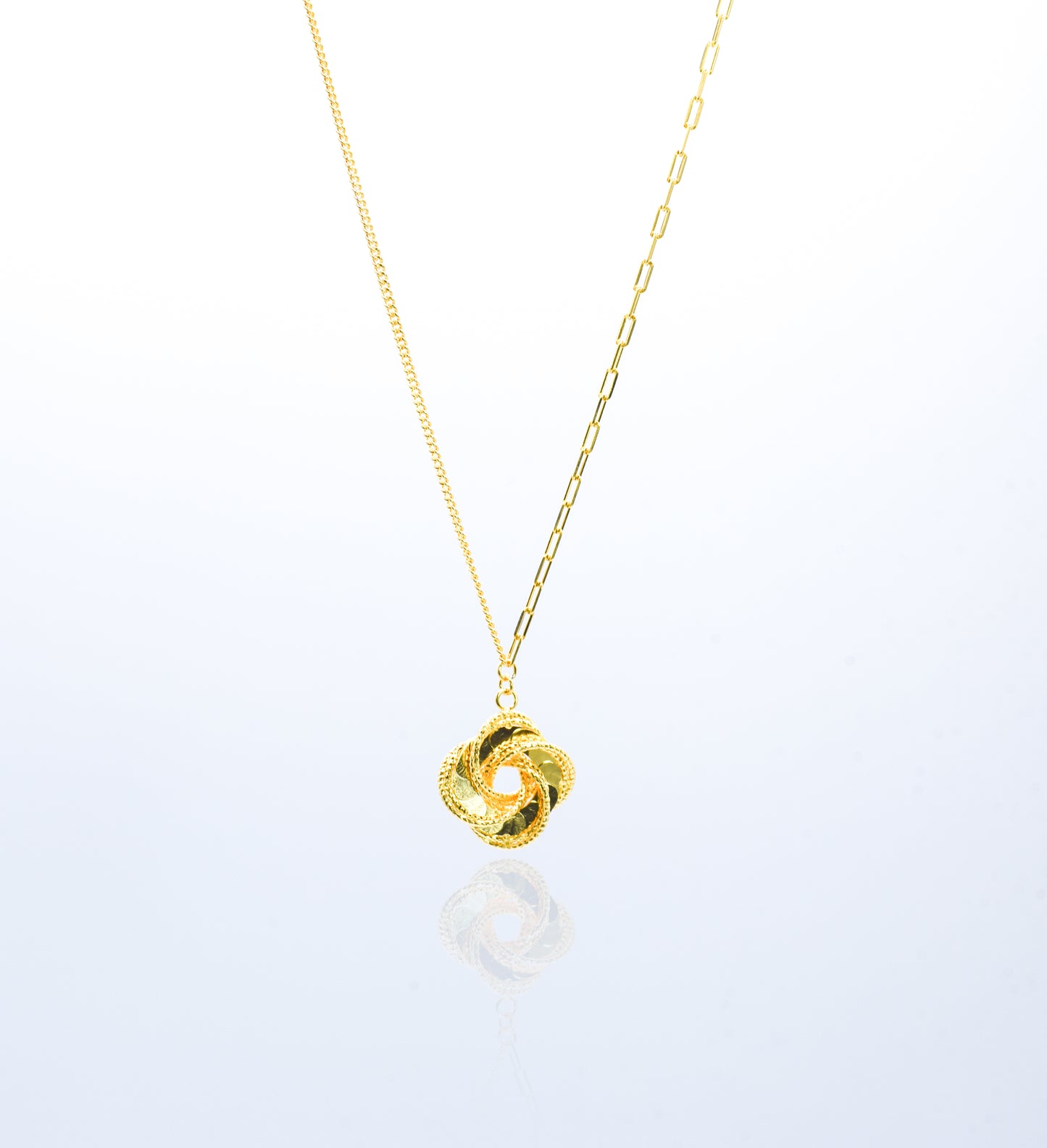 Gold color necklace with a unique pendant on a white background