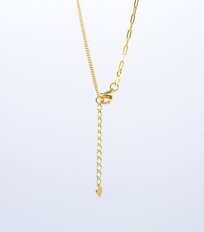 Gold color necklace chain with a light gray background