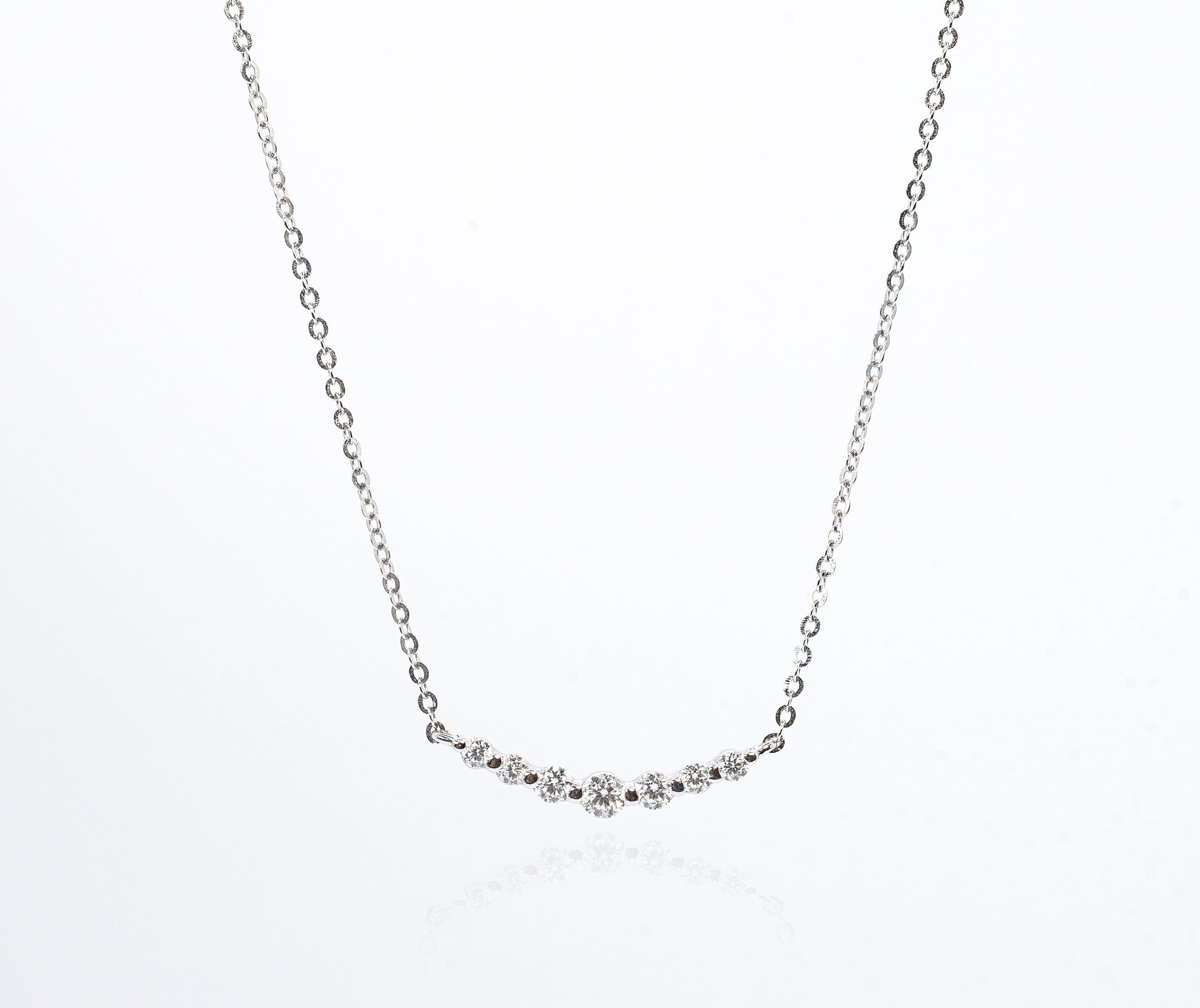 Delicate silver necklace with small Moissanite Stones on a white background