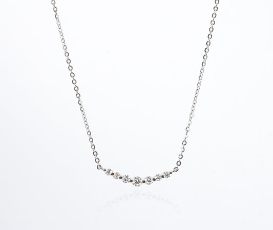 Delicate silver necklace with small Moissanite Stones on a white background